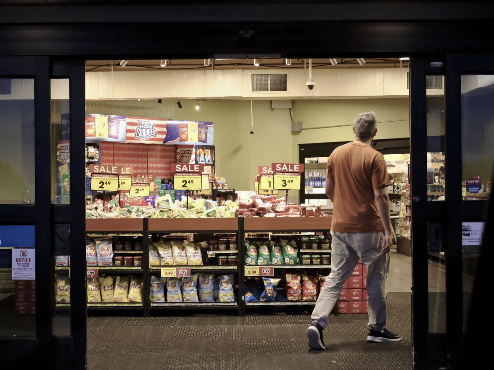 Una persona ingresa por la puerta principal de un supermercado