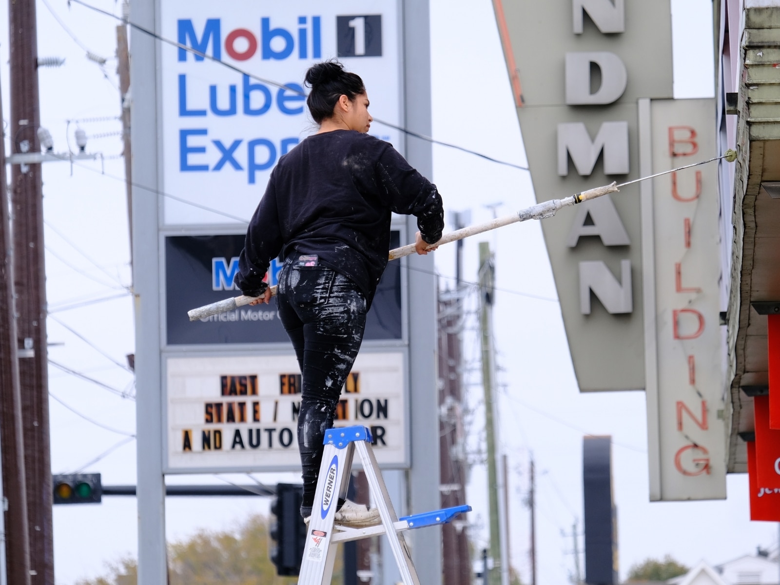 Una mujer de origen hispano realiza labores de pintura en un negocio ubicado en el centro de Houston