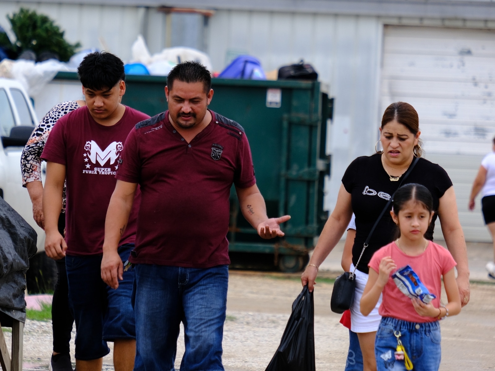 Una familia de origen hispano recorre las calles de un centro de venta callejera en la ciudad de Pearland, Texas