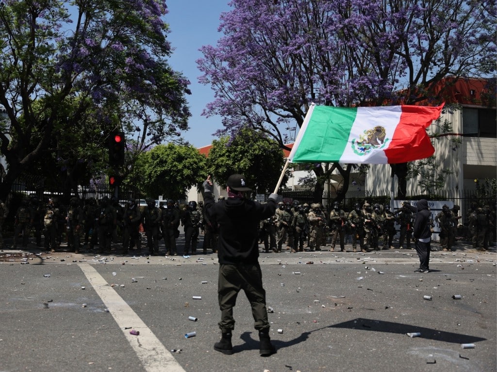 Foto de un manifestante con una bandera mexicana durante una protesta contra las redadas de ICE en Paramount, California