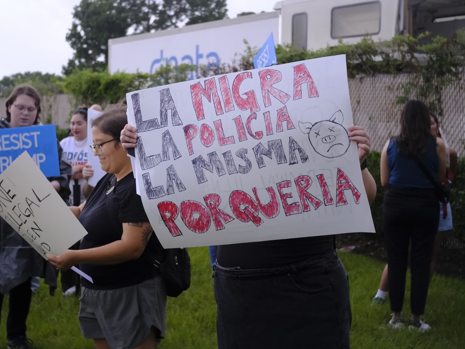 Varios manifestantes sostienen pancartas con consignas en contra de las redadas migratorias en una marcha pacífica convocada en Houston, Texas.