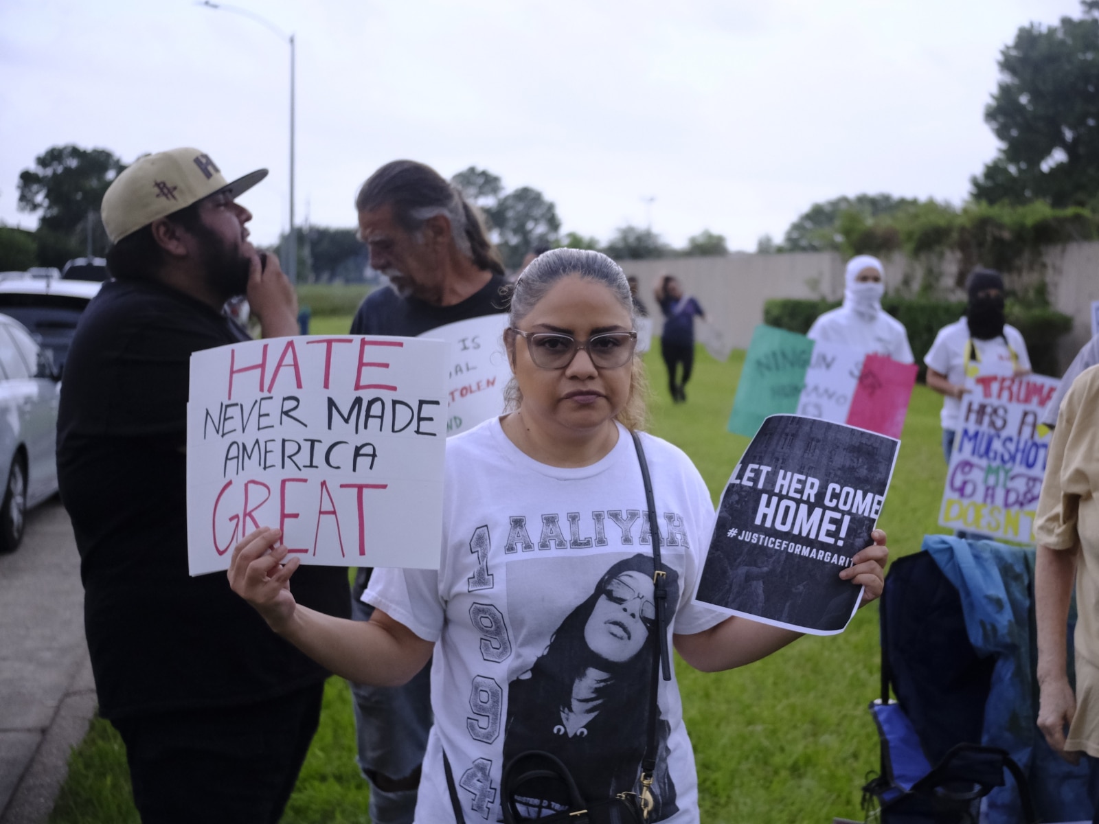 Una mujer no identificada sostiene pancartas con consignas en contra de las redadas migratorias en una marcha pacífica convocada en Houston, Texas