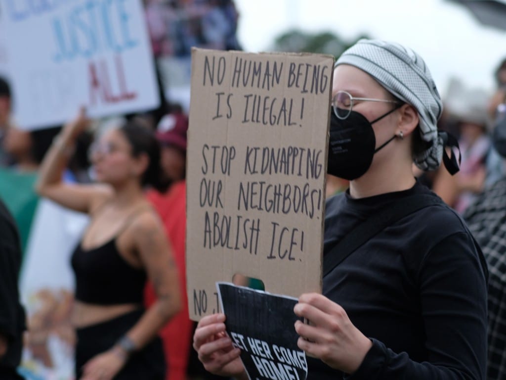 Varios manifestantes sostienen pancartas con consignas en contra de las redadas migratorias en una marcha pacífica convocada en Houston, Texas, el 13 de junio de 2025.