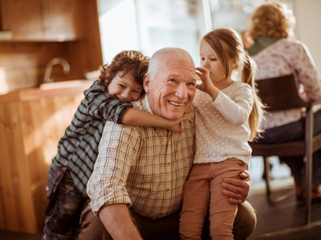 Imagen de una persona mayor junto a dos niñas.