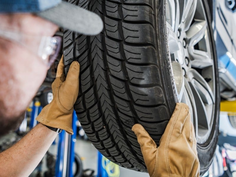 Imagen de un mecánico revisando los neumáticos.