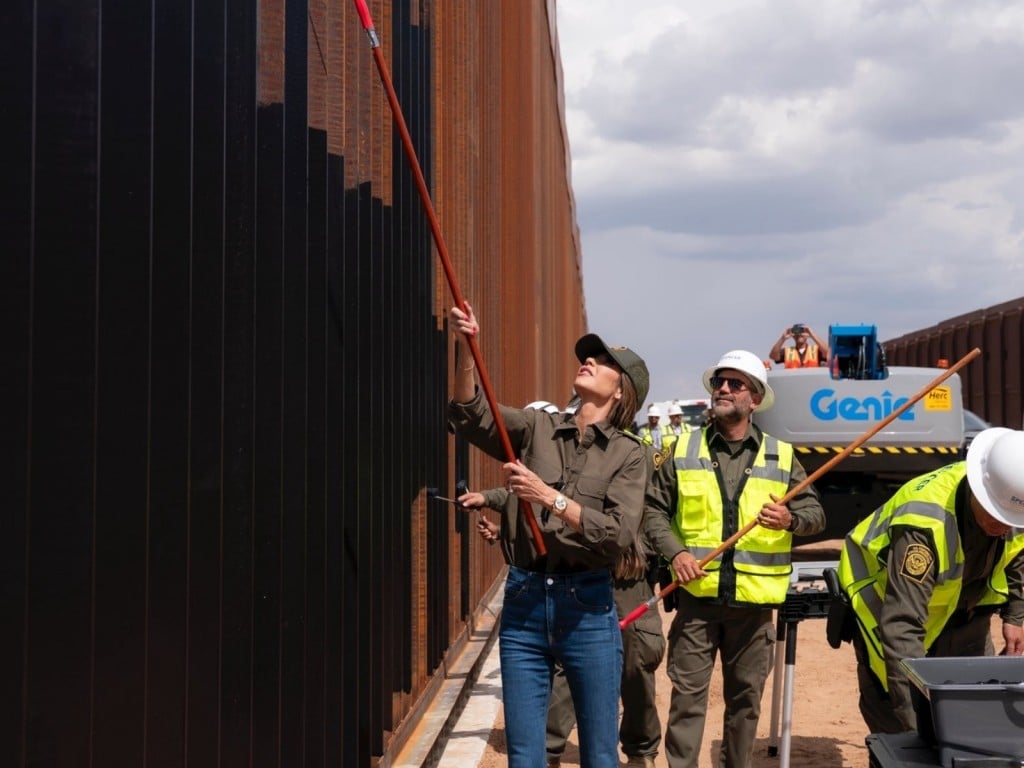 Kristi Noem, la secretaria del DHS, pinta parte del muro fronterizo con México