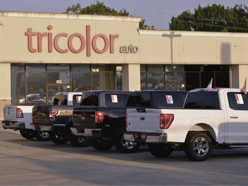 Varias camionetas permanecen estacionadas frente a una sucursal cerrada de Tricolor Auto en el norte de Houston, tras la declaración de bancarrota de la empresa. (Foto: La Esquina TX)
