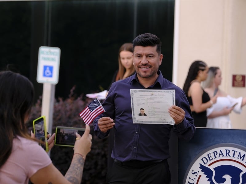Un hombre de origen hispano posa con el certificado que le concede la ciudadanía estadounidense luego de una ceremonia de naturalización