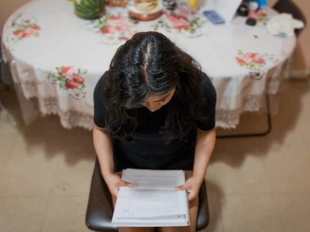 Imagen de una inmigrante con un fajo de papeles administrativos