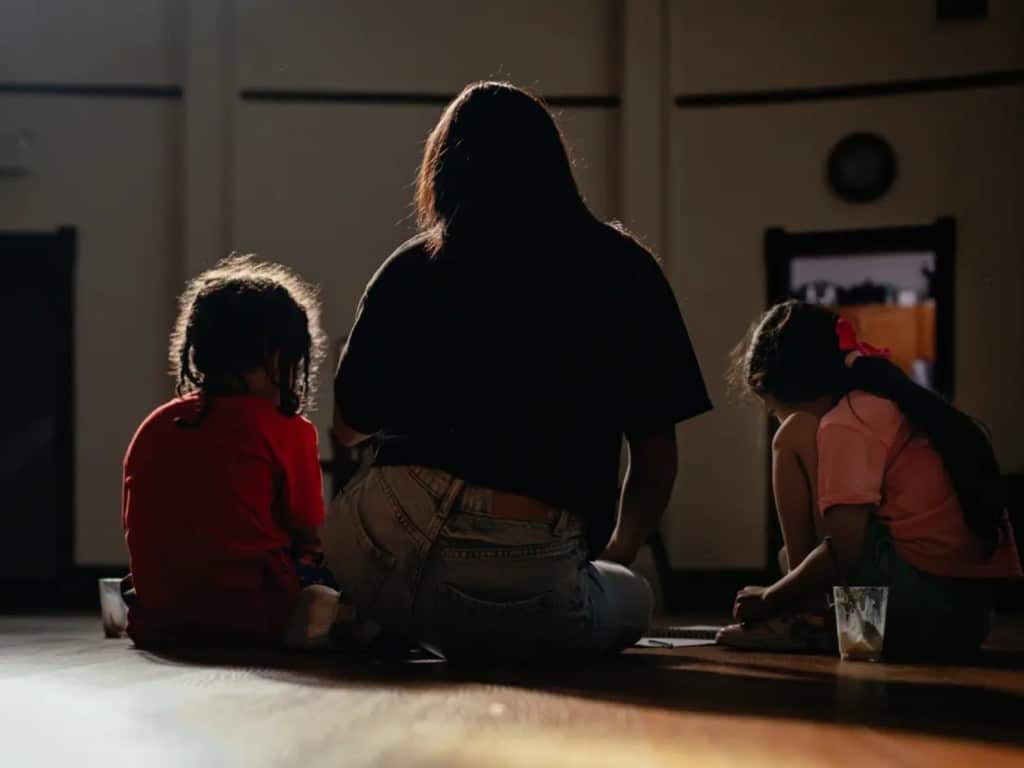 Una mujer juega con sus dos hijos