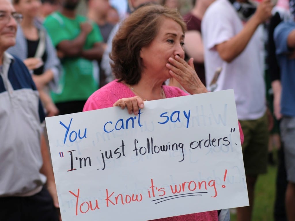 Mujer sostiene una pancarta en una protesta