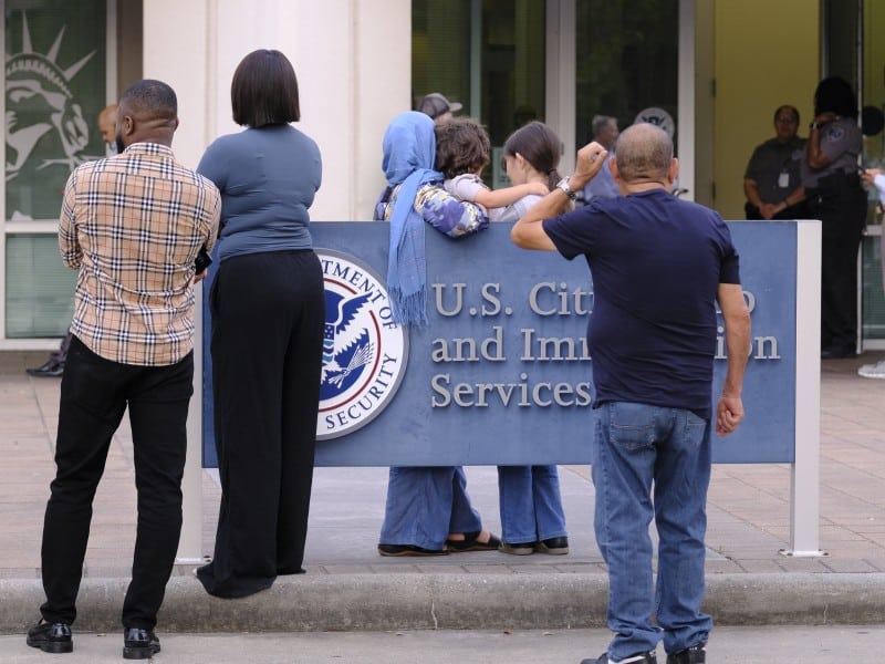 Un grupo de personas espera en las afueras de la sede del Servicio Nacional de Ciudadanía e Inmigración de EE. UU. (ICE) en Houston, Texas