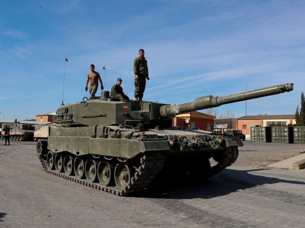Tres personas subidos a un tanque