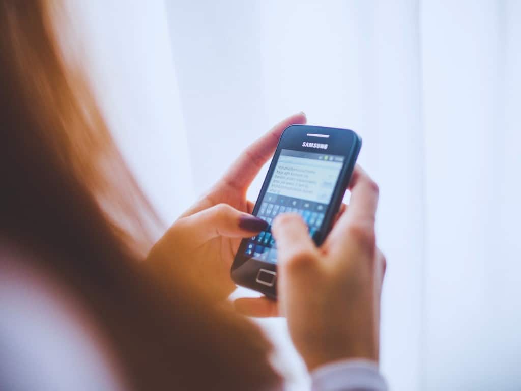 Una mujer usando su celular