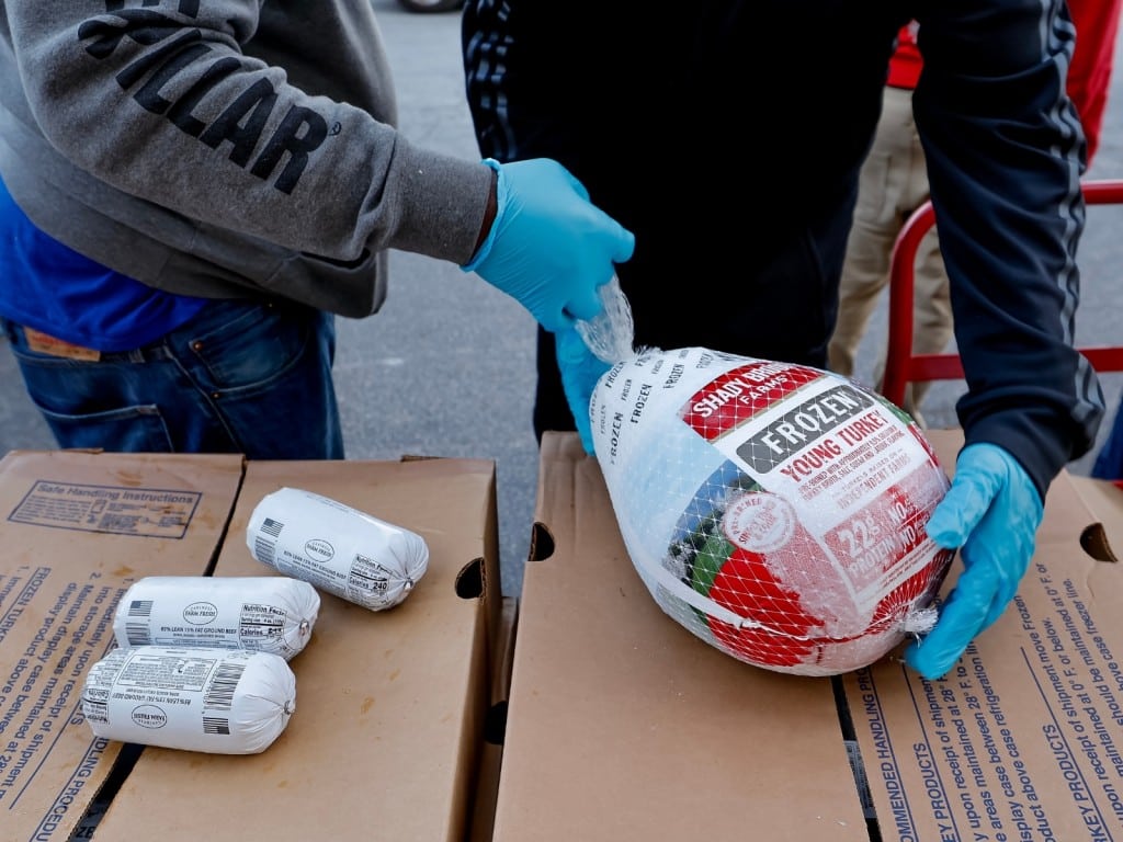 Imagen de dos personas con un pavo congelado