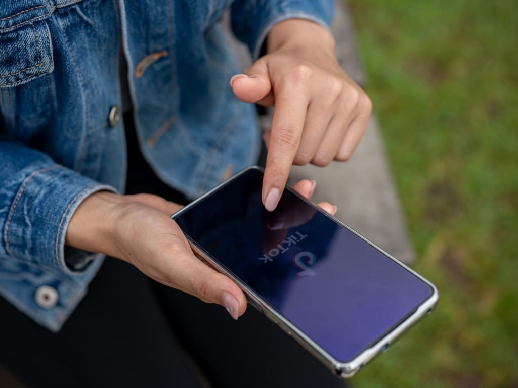 Una mujer usando TikTok en su celular