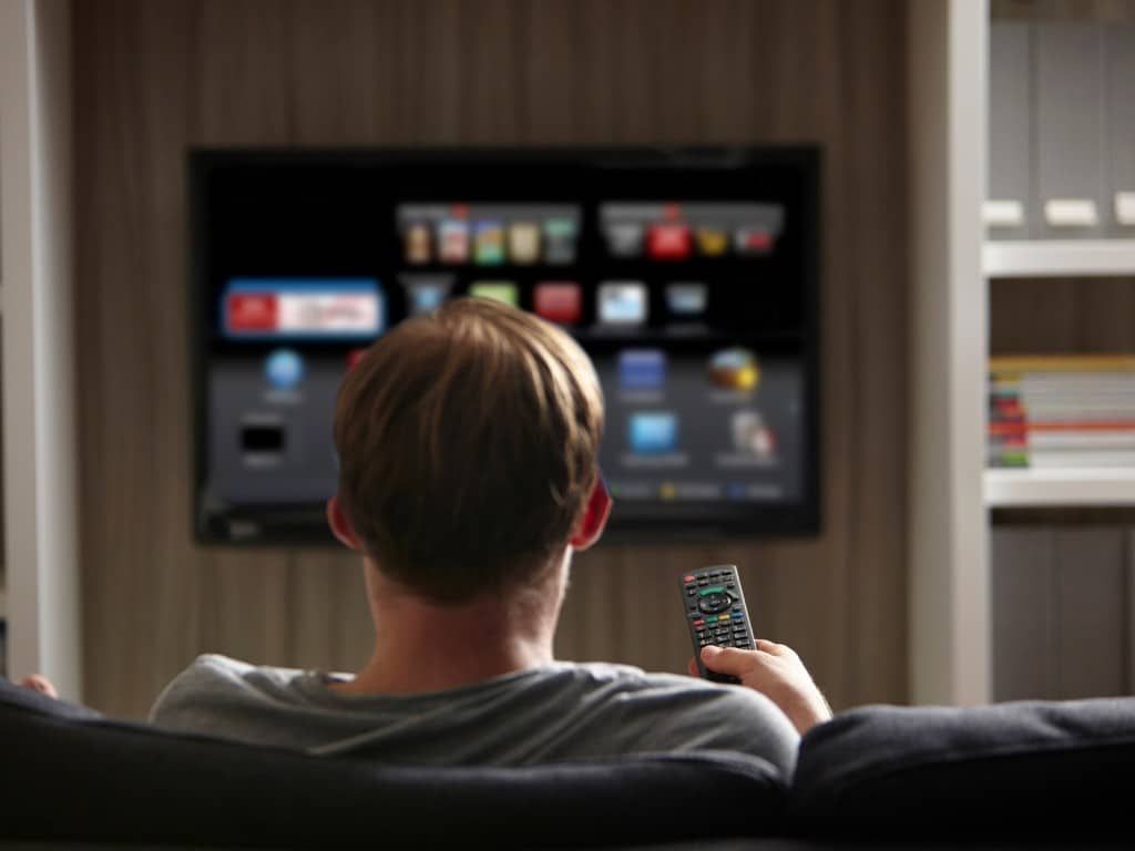 Imagen de una persona viendo un servicio de streaming frente a su TV