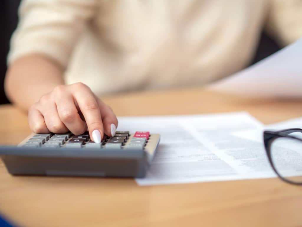 Imagen de una persona usando una calculadora sobre un escritorio.