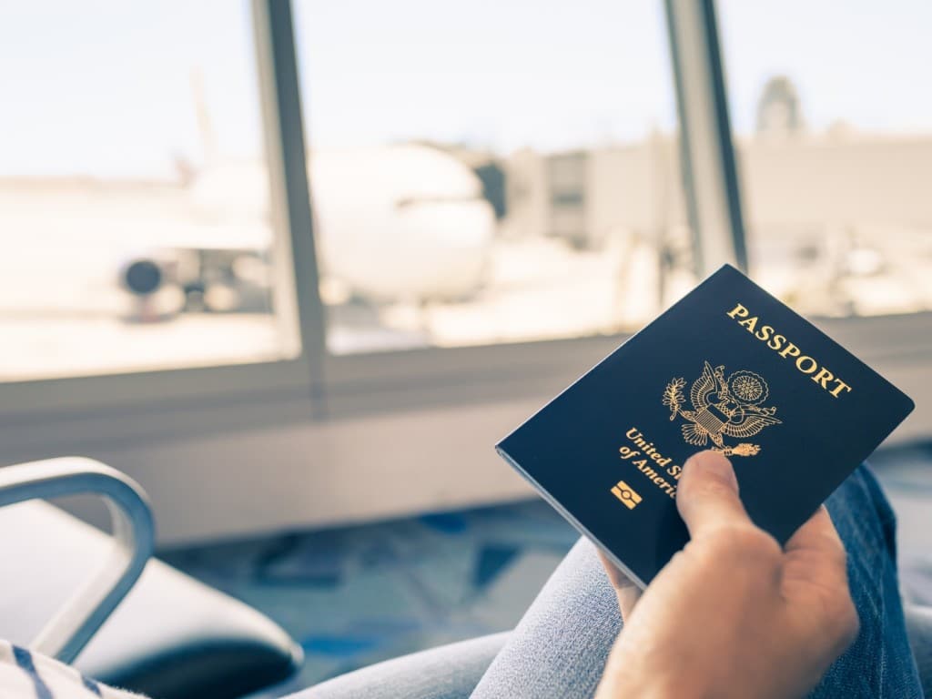 Imagen de una persona sosteniendo un pasaporte de los EE. UU. en el aeropuerto