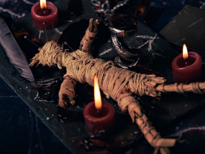 Imagen de un muñeco de trapo junto a una velas