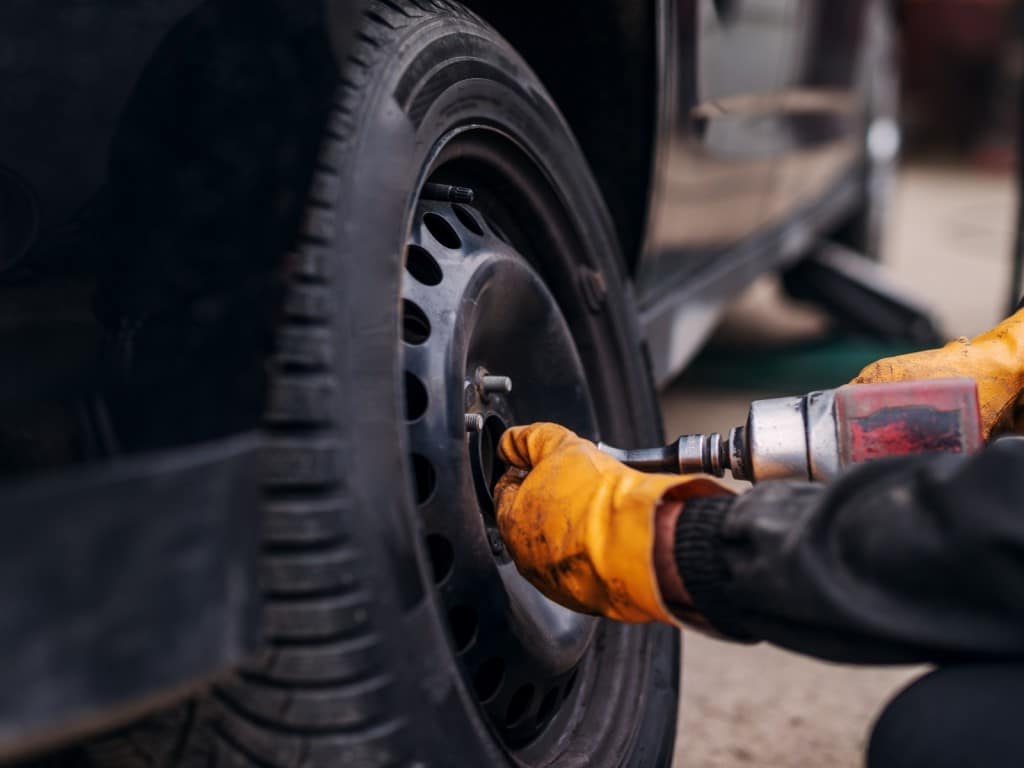 Imagen de un mecánico cambiando un neumático