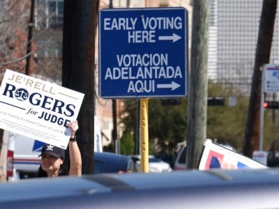 Una mujer no identificada sostiene un cartel publicitario de un candidato en Houston, Texas.