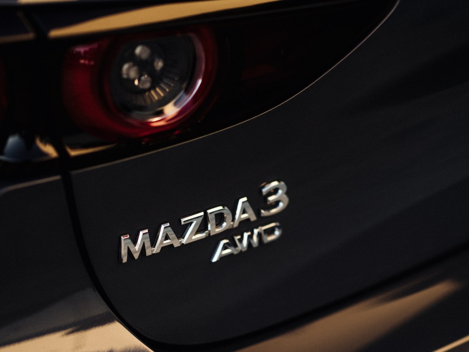 Detalle del emblema Mazda3 AWD en la zaga del vehículo