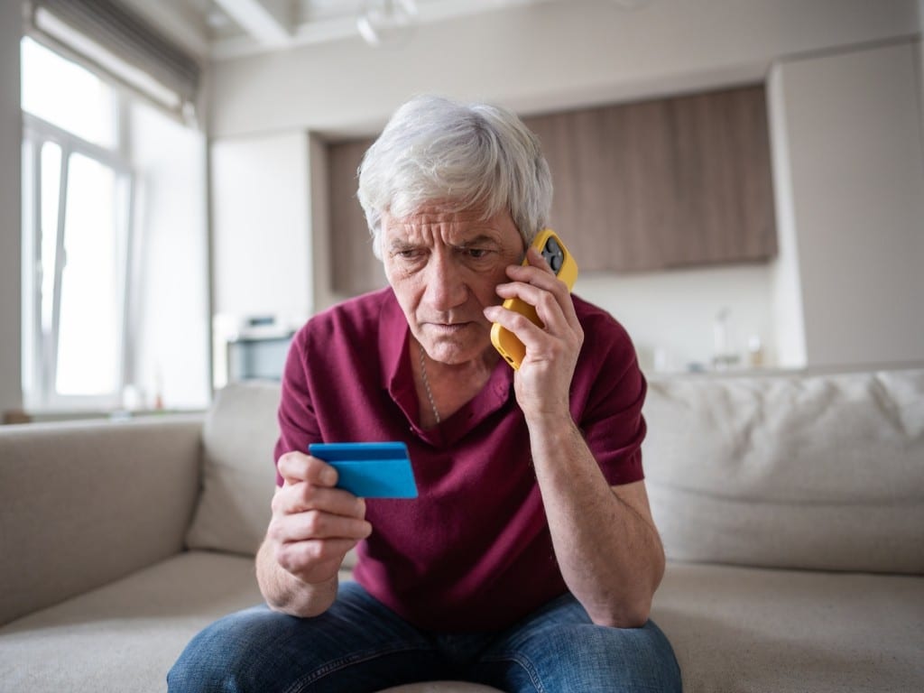 Una persona sentada y escuchando una llamada por teléfono