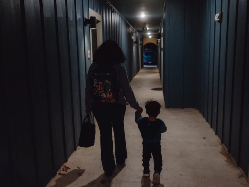 Una voluntaria escolta a un niño estadounidense de 2 años para reunirlo con su madre