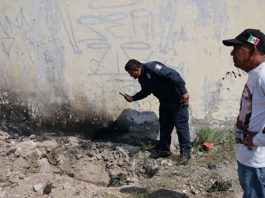 Un policía toma una foto en el lugar donde un pariente de una persona desaparecida
