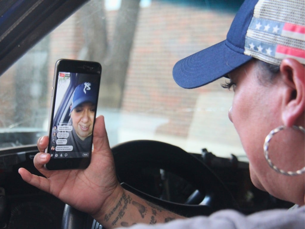 Priscilla Villarreal, conocida como “La Gordiloca”, revisa una transmisión en vivo desde su vehículo