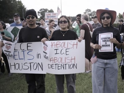 Varios manifestantes sostienen pancartas con consignas en contra de las redadas migratorias