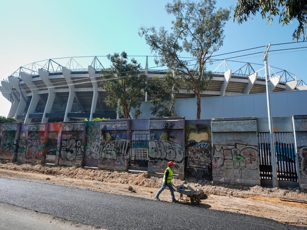 Un obrero empuja en una carretilla en las afueras del Estadio Azteca