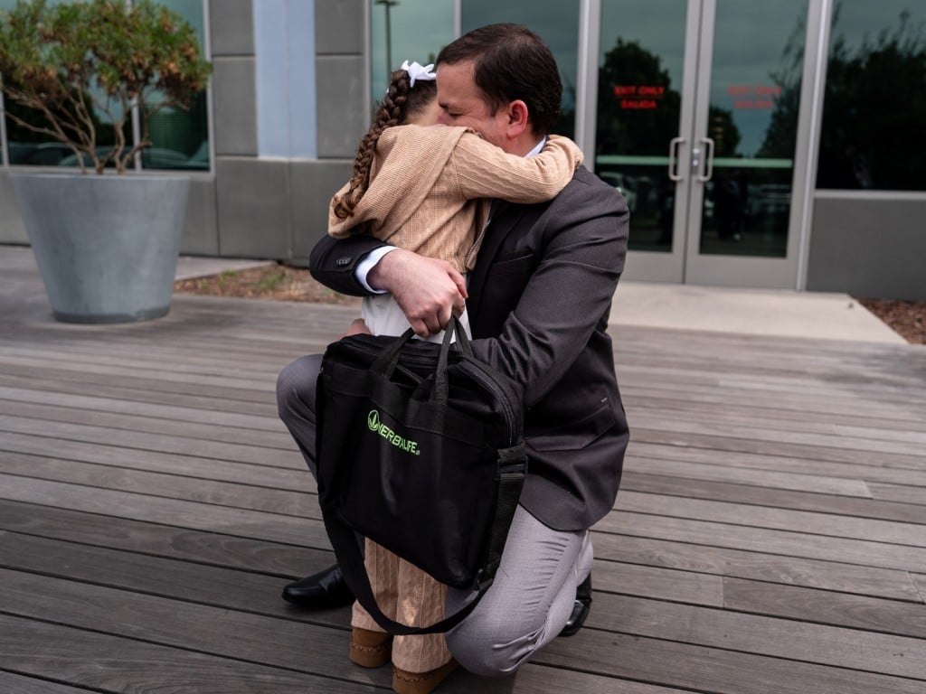 Padre abraza a su hija tras su entrevista por asilo con las autoridades migratorias