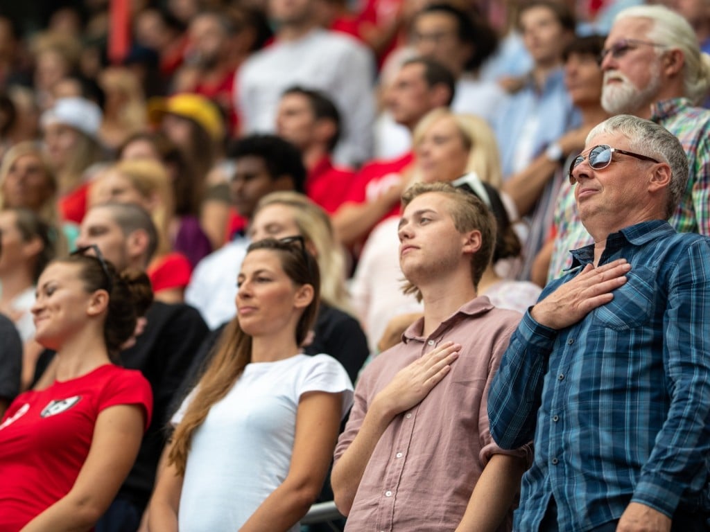 Un grupo de personas a punto de entonar el himno nacional