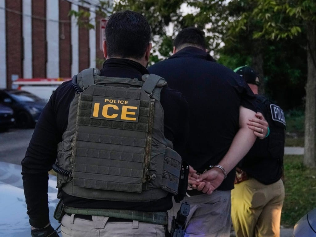 Agentes de ICE detienen a una persona.