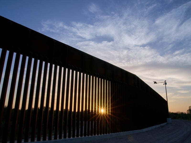 El sol se pone tras una sección del muro fronterizo