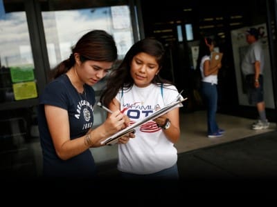 Fabiola Vejar (derecha), registra a Stephanie Cardenas para votar frente a un supermercado latino en Las Vegas