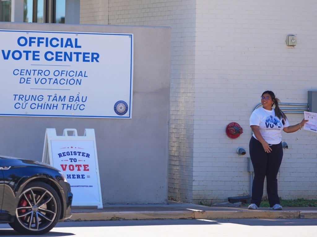 Un voluntario ayuda a un conductor a registrarse para votar en Dallas, Texas