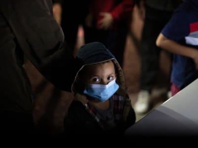 Un niño espera a responder preguntas de un agente de la Patrulla Fronteriza de Estados Unidos