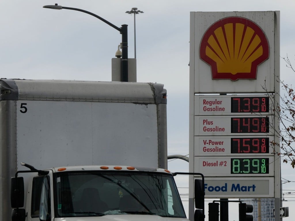 Un camión pasa ante un cartel con precios de gasolina y diésel
