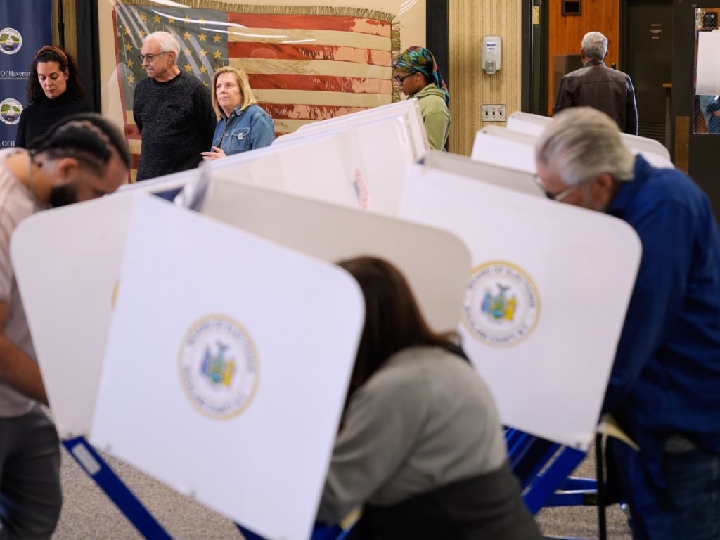 Varias personas esperan en línea para que se habiliten cabinas privadas para votar